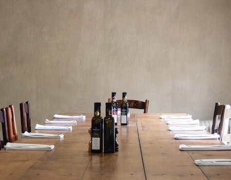 Plateau repas entreprise - Crior, traiteur professionnel ! Image représentant une grande table avec 5 chaises en bois + serviettes blanches sur la table @pexels-karen-laårk-boshoff-7436113