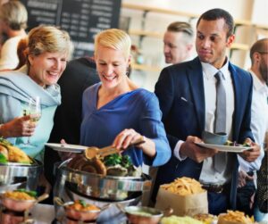 5 Conseils pour un buffet déjeunatoire réussi - personnes se servant lors d'un buffet - Crior Traiteur Entreprise